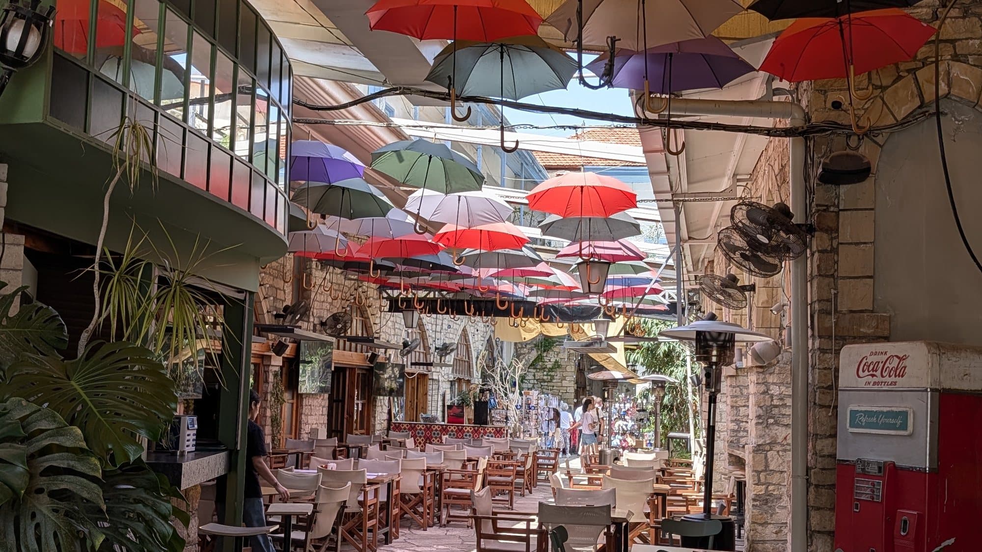 A pedestrian lane in Nicosia's old town shaded by rows of coloured umbrellas.